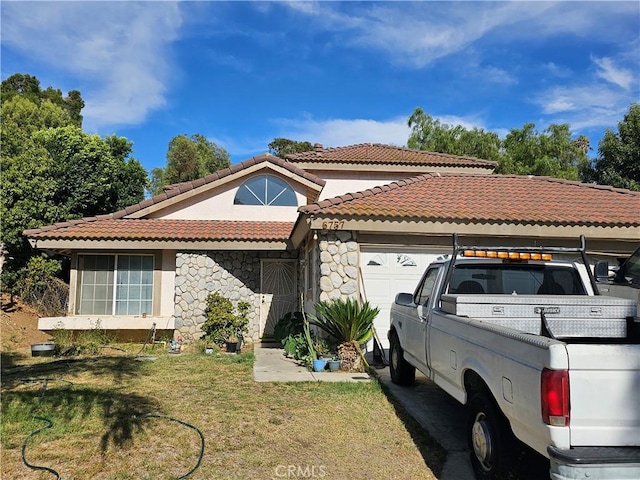 6757 Sunnyvale Dr, Riverside, CA 92505 - mediterranean / spanish-style house featuring a tiled roof, stone siding, an attached garage, a front yard, and stucco siding