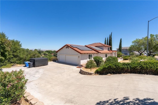 view of property exterior with a garage and solar panels