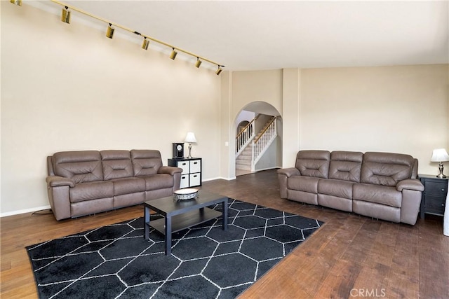 living room with dark wood-type flooring and rail lighting