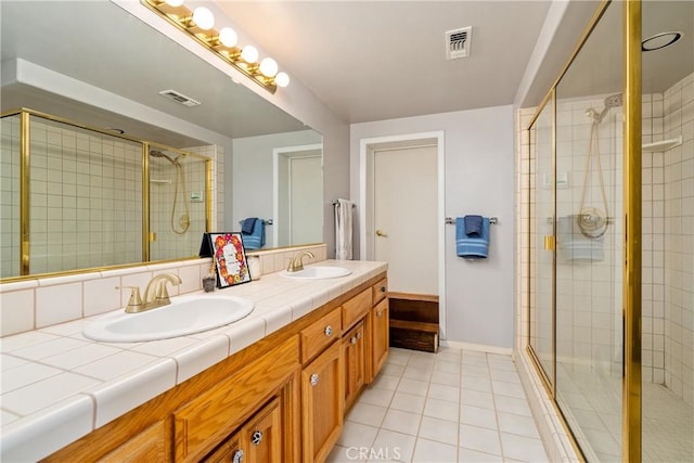 bathroom with tile patterned flooring, vanity, and a shower with door