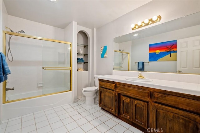 full bathroom featuring tile patterned flooring, vanity, combined bath / shower with glass door, and toilet