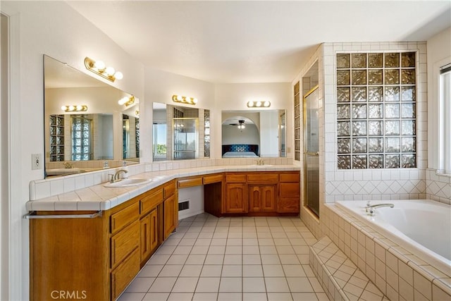 bathroom with plus walk in shower, tile patterned floors, ceiling fan, and vanity