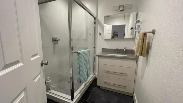 bathroom with vanity, a shower with shower door, and tile patterned floors