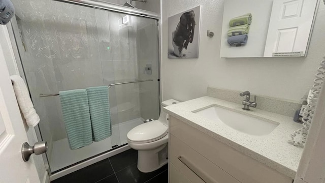 bathroom with vanity, toilet, tile patterned flooring, and an enclosed shower