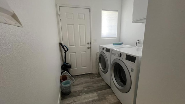 clothes washing area featuring washing machine and clothes dryer and dark hardwood / wood-style flooring