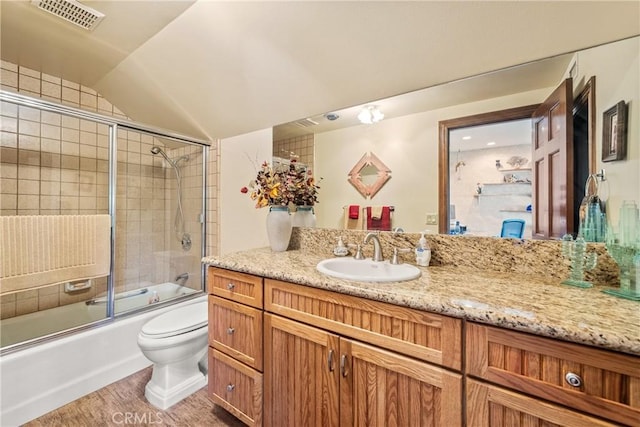 full bathroom with toilet, vanity, vaulted ceiling, hardwood / wood-style floors, and enclosed tub / shower combo