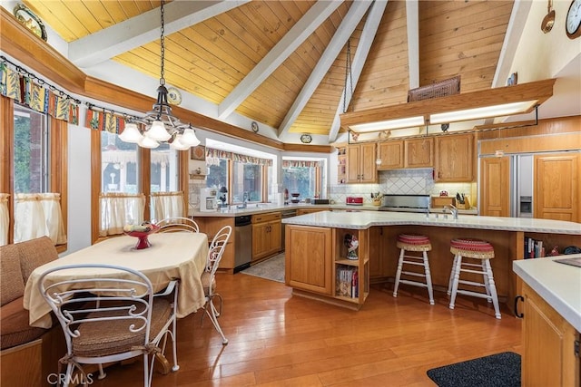 kitchen with a center island, decorative light fixtures, beamed ceiling, tasteful backsplash, and a breakfast bar