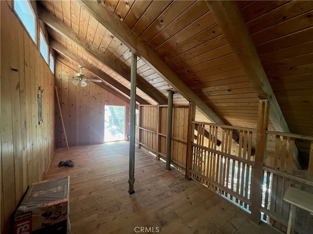 additional living space featuring vaulted ceiling with beams, hardwood / wood-style floors, ceiling fan, wooden ceiling, and wooden walls