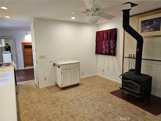 interior space featuring a wood stove and ceiling fan