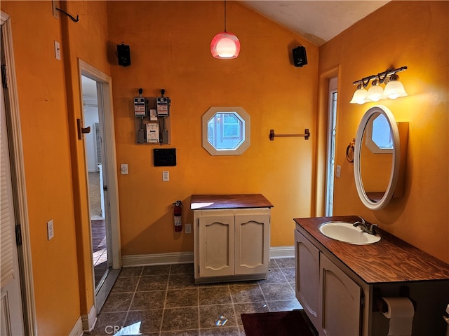 bathroom featuring vanity, lofted ceiling, and tile patterned flooring