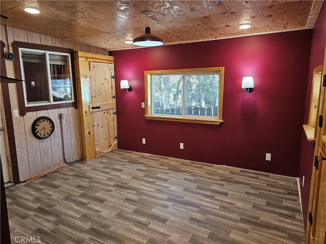 interior space with hardwood / wood-style floors, wooden ceiling, and wood walls