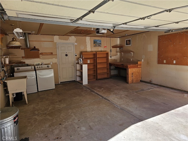 garage with a garage door opener, washer and dryer, and sink