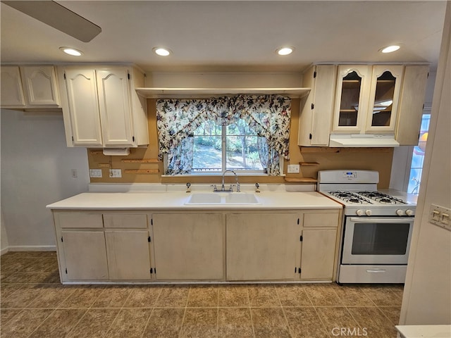 kitchen with sink, white range with gas cooktop, and tile patterned flooring