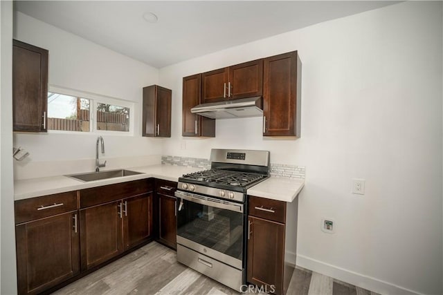 kitchen with sink, dark brown cabinetry, stainless steel range with gas stovetop, and light hardwood / wood-style floors