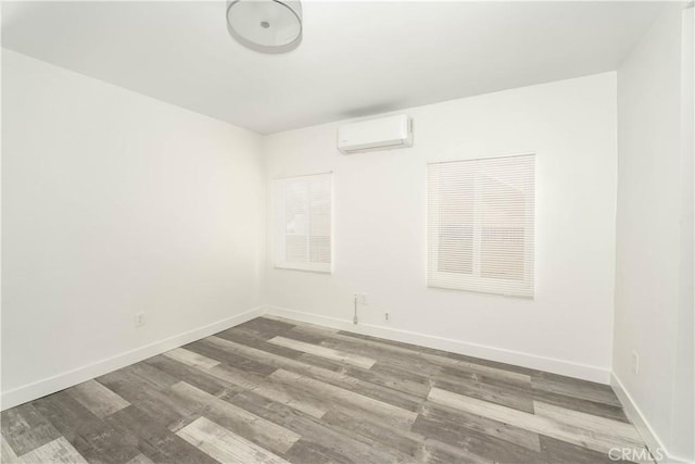 unfurnished room featuring hardwood / wood-style flooring and a wall mounted AC