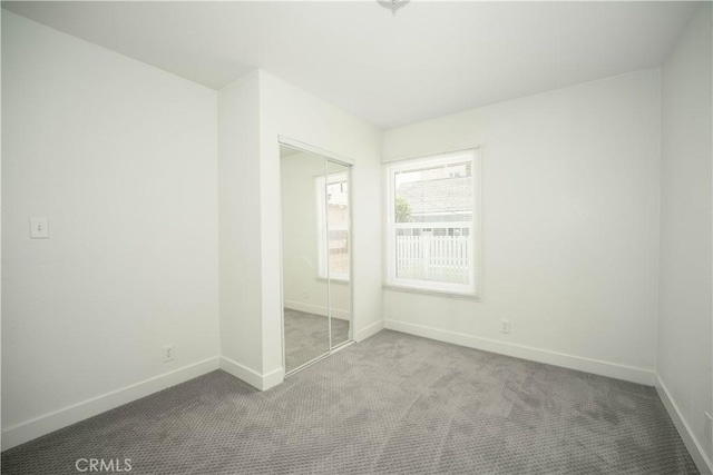 unfurnished bedroom featuring a closet and carpet flooring