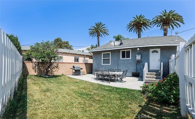 rear view of house with a yard and a patio