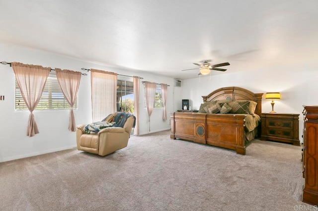 bedroom featuring ceiling fan, light carpet, and multiple windows