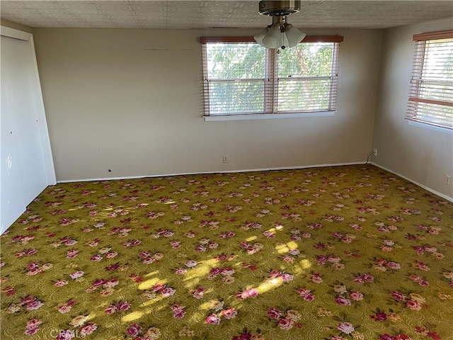 carpeted empty room featuring ceiling fan