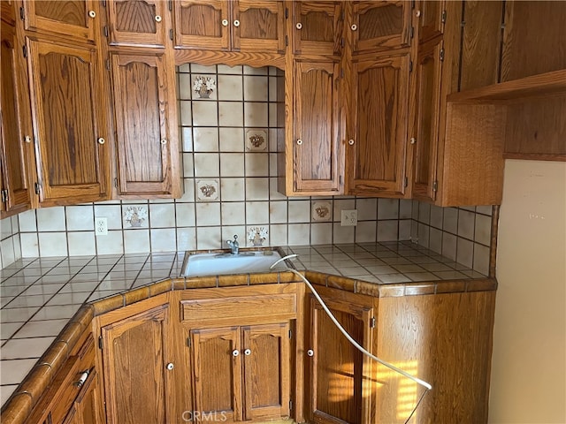 kitchen with sink, tile countertops, and backsplash