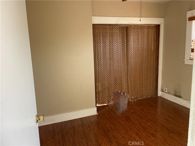 unfurnished bedroom with a closet and dark hardwood / wood-style flooring