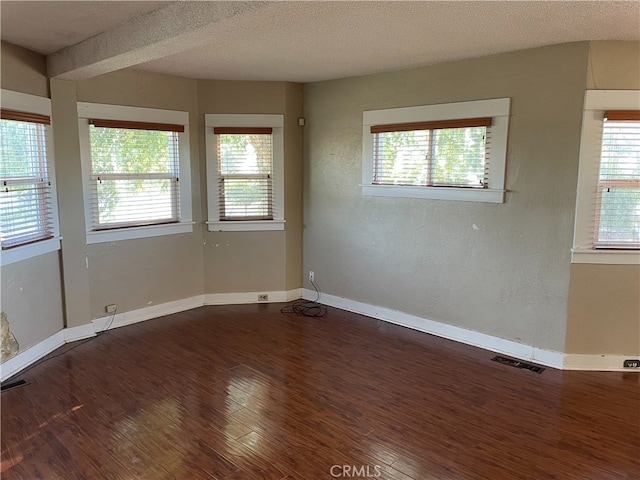 spare room featuring a textured ceiling and hardwood / wood-style floors