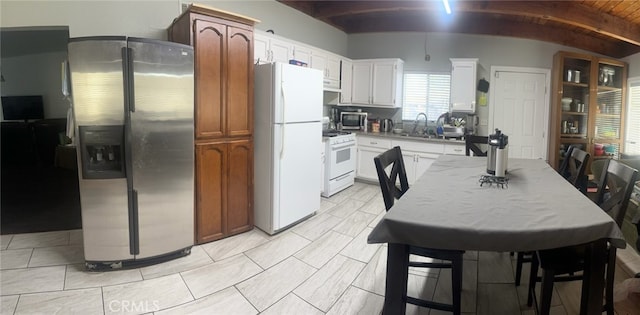 kitchen featuring white cabinets, stainless steel appliances, lofted ceiling with beams, and wood ceiling