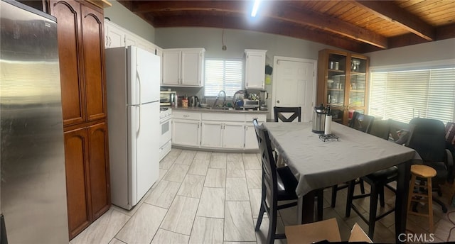 kitchen featuring white refrigerator, beamed ceiling, stainless steel fridge, wooden ceiling, and a breakfast bar