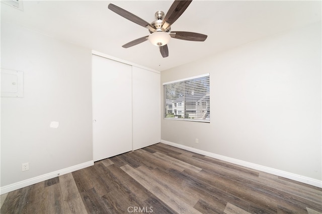 unfurnished bedroom with a closet, dark hardwood / wood-style floors, and ceiling fan