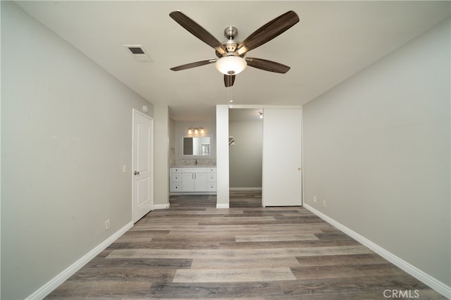 unfurnished bedroom featuring a closet, ensuite bath, ceiling fan, and light hardwood / wood-style floors