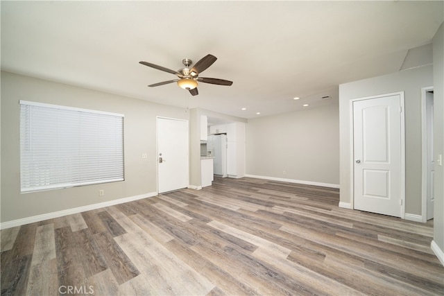 unfurnished living room featuring wood-type flooring and ceiling fan