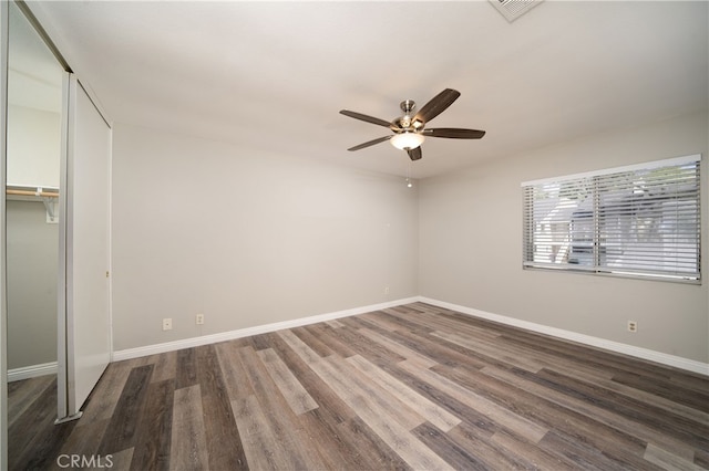 unfurnished bedroom with a closet, ceiling fan, and dark wood-type flooring