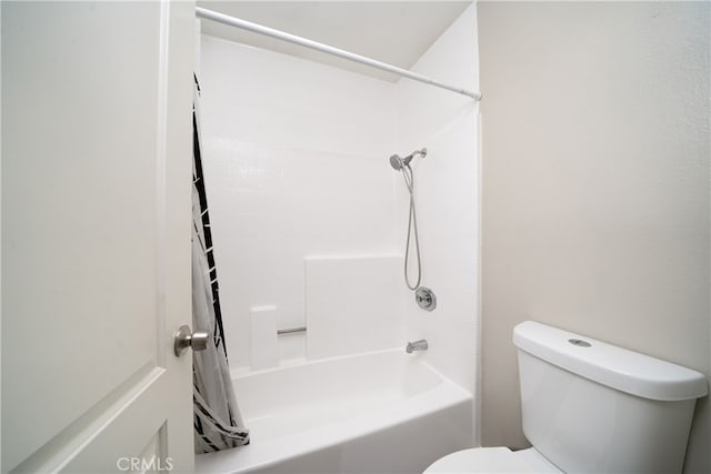 bathroom featuring shower / bath combo with shower curtain and toilet