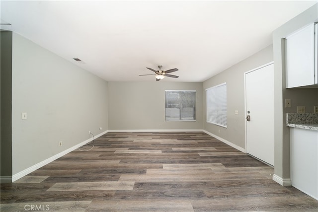 empty room featuring ceiling fan and dark hardwood / wood-style flooring