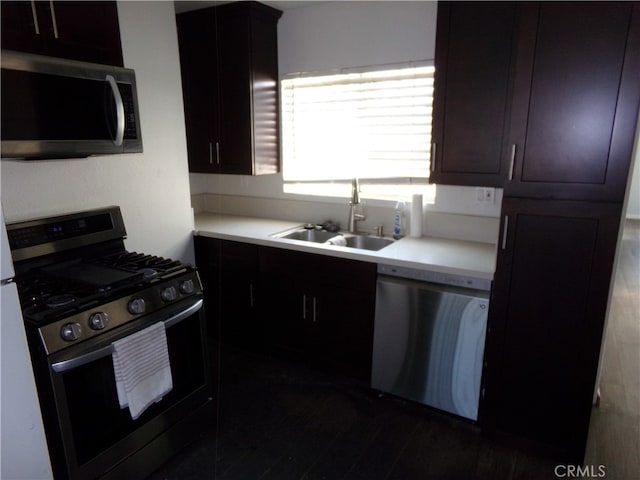 kitchen with dark brown cabinets, stainless steel appliances, and sink