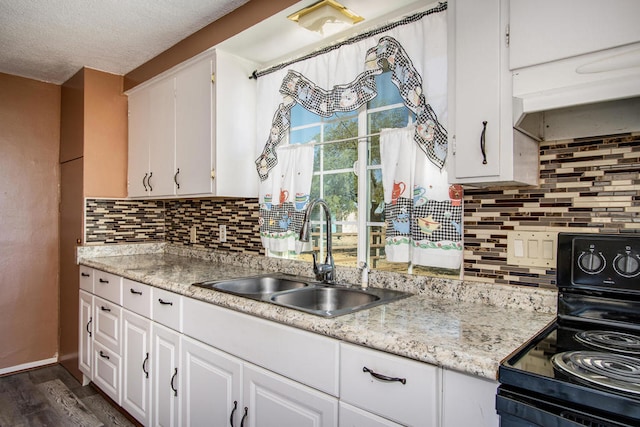 kitchen with dark hardwood / wood-style floors, black stove, backsplash, sink, and white cabinetry