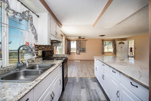 kitchen with black range with electric stovetop, sink, white cabinetry, and dark hardwood / wood-style floors