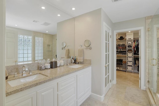 bathroom featuring tile patterned flooring, vanity, and an enclosed shower