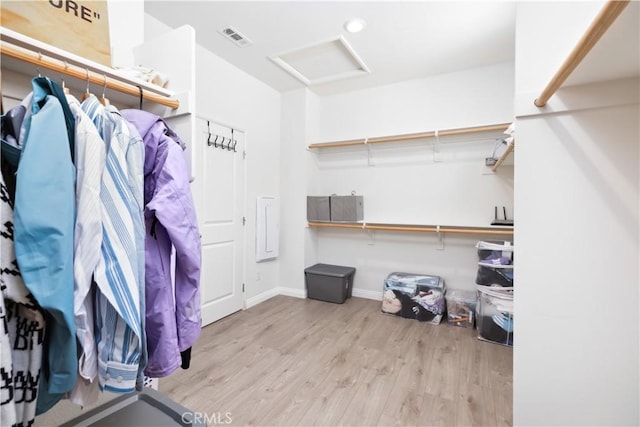 walk in closet with light hardwood / wood-style floors