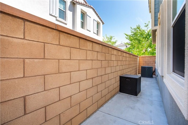 view of property exterior with cooling unit and a patio