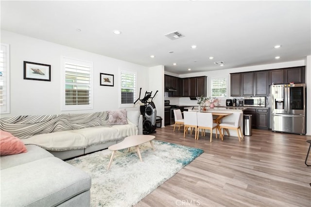 living room featuring plenty of natural light and light hardwood / wood-style flooring