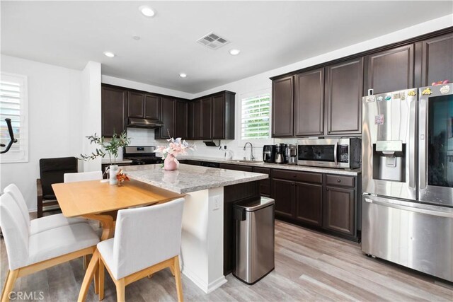 kitchen featuring light stone counters, stainless steel appliances, sink, light hardwood / wood-style flooring, and dark brown cabinets