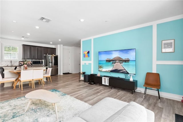 living room with sink and light wood-type flooring