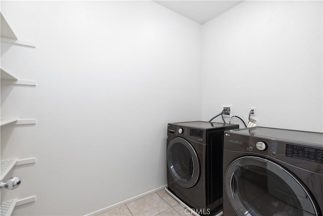 clothes washing area with separate washer and dryer and light tile patterned floors