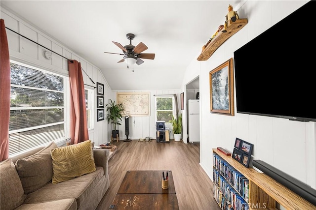 living room with ceiling fan, wood-type flooring, and lofted ceiling