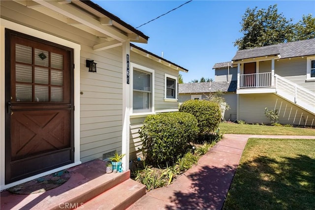 property entrance with a lawn