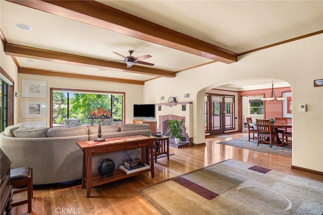 living room with ceiling fan, hardwood / wood-style flooring, and beamed ceiling