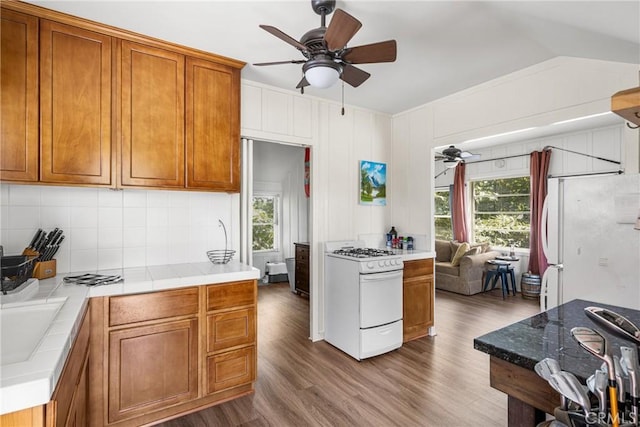 kitchen with ceiling fan, white appliances, hardwood / wood-style floors, and a healthy amount of sunlight