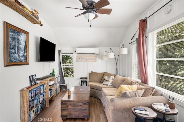 living room with a wall mounted AC, vaulted ceiling, dark hardwood / wood-style flooring, and plenty of natural light