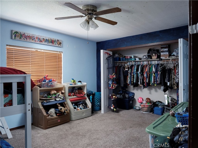 bedroom with carpet floors, a textured ceiling, ceiling fan, and a closet